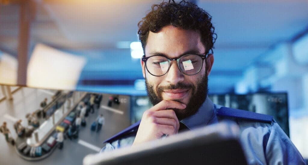 Operador de seguridad monitoreando imágenes de videovigilancia en un aeropuerto